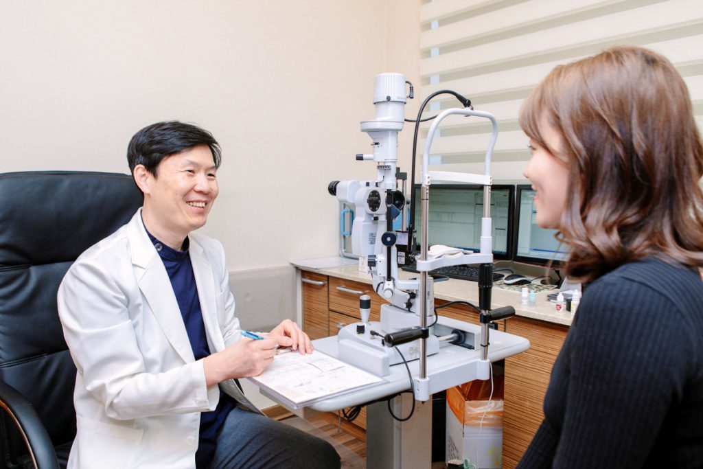 라식수술비용 및 수술 가능 여부를 검사받기 위해 찾아온 환자의 정밀검사 결과를 검토하고 추가 진료를 보고 있는 아이플러스안과 이용재 대표원장님의 모습