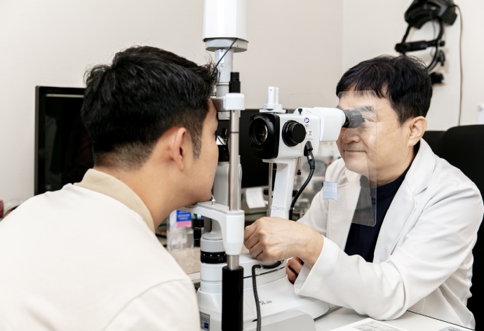 아이플러스안과 최용석 원장님이 환자의 눈 상태를 확인하는 모습